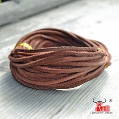 a close up of a brown cord on a white plate with flowers in the background