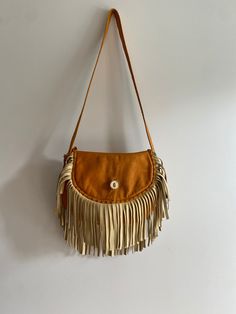 Soft and supple hand made leather and fringe crossbody purse There is one interior snap pocket and a bone or horn button closure with a decorative tassle  Fringe is a creamy suede 70's era in amazing condition so so so soft! Bohemian Saddle Shoulder Bag For Everyday Use, Bohemian Saddle Bag For Everyday Use, Vintage Everyday Bags With Tassels, Western Style Fringe Bags For Everyday Use, Western Style Bags With Fringe For Everyday Use, Western Style Fringed Bags For Everyday Use, Vintage Leather Bags With Fringe, Leather Fringe Pouch Bag, Brown Fringe Pouch Shoulder Bag