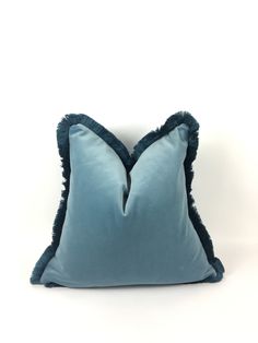 a blue pillow with ruffled edges on a white background