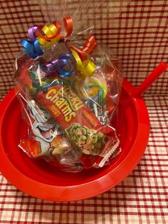 a red bowl filled with candy on top of a table