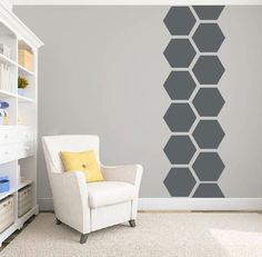 a white chair sitting in front of a wall with hexagons on it