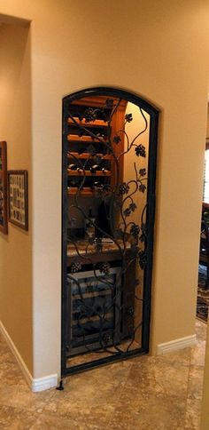 an ornate iron door in the corner of a room with tile flooring and beige walls