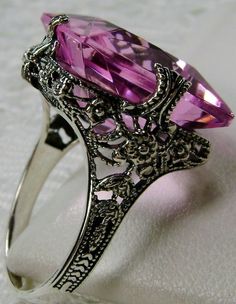 Simulated Pink Topaz Ring SquareVic Design#77 Made To Order This is a brand new Victorian era reproduction floral filigree ring in sterling silver. The rare filigree ring is set with a high-quality man-made/simulated pink topaz. The gemstone is 15mm (about 9/16th of an inch) in length and 15mm in width. The rings stand about 8mm off the finger. The inside of the band is marked 925 for sterling. This is a lovely new, well-made ring and it is ready to wear. A ring gift box included and all rings a Exquisite Amethyst Wedding Ring, Exquisite Silver Amethyst Ring For Wedding, Victorian Amethyst Ring With Accent Stones For Formal Occasions, Art Deco Filigree Ring With Center Stone As Gift, Antique Filigree Ring With Center Stone As Gift, Amethyst Rings With Intricate Design For Wedding, Pink Rings With Intricate Design For Anniversary, Vintage Amethyst Ring With Accent Stones For Wedding, Antique Topaz Ring With Accent Stones For Formal Occasions