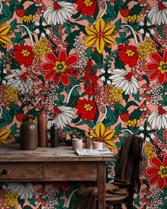 a wooden table sitting in front of a wall with flowers on it