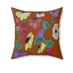 an orange pillow with colorful flowers on it