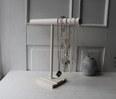 a white shelf with jewelry hanging from it's sides