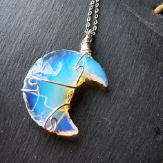 🖤 Here is a beautiful hand carved Opalite necklace pendant,  moon - wire wrapped with copper filled silver plated wire. 🖤🌛Chain finishes are available too- choose from 20 inch silver plated chain or a 20 inch stainless steel chain finish.. Please choose from the drop down menu!  Enjoy the benefits of wearing this opalite moon pendant! 🌝 Opalite Necklace Pendants, Opalite Necklace, Opalite Crystal, Crystal Moon, Moon Moon, Witch Jewelry, Wrapped Necklace, Moon Pendant Necklace, Moon Crystal