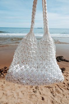 a large white bag sitting on top of a sandy beach next to the ocean,