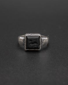 This unique ring features an epitome of grace, a deer impeccably carved into matte onyx set splendidly on a sterling silver ring and further enhanced with intricate wired detail. This item will ship directly from Bali via DHL delivery. Please allow up to 15 business days to arrive. Sterling Silver Intaglio Engraved Ring For Formal Occasions, Formal Sterling Silver Engraved Ring With Intaglio, Symbolic Carved Jewelry For Formal Occasions, Formal Sterling Silver Intaglio Engraved Ring, Elegant Silver Signet Ring With Intaglio, Elegant Silver Carved Signet Ring, Black Carved Ring Jewelry, Black Carved Sterling Silver Jewelry, Silver Elegant Intaglio Signet Ring