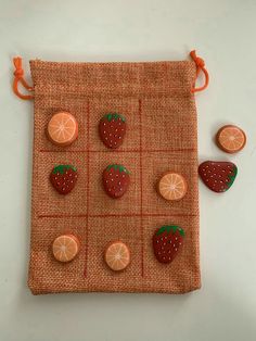 oranges and strawberries are arranged on an orange - colored fabric bag with matching buttons