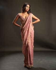 This dusty pink saree is a vision of elegance, crafted from shimmering tissue fabric that glimmers with every movement. Paired with a raw silk blouse, the ensemble exudes sophistication and charm. The intricately hand-embroidered blouse adds a touch of glamour, making it perfect for a cocktail or reception, whether for the bride or her bridesmaids. With its timeless allure and delicate detailing, this saree is sure to captivate attention and leave a lasting impression on any special occasion.Fro Dusty Pink Saree, Pink Sari, Tissue Fabric, Raw Silk Blouse, Tuxedo Accessories, Net Blouses, Summer Romance, Traditional Sarees, 12 Weeks