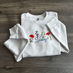 Step into a world of natural elegance with our latest Wildflower Sweatshirt Collection - where comfort meets botanical beauty in every stitch! Crafted from soft, high-quality materials, our sweatshirts are as cozy as they are chic.  Whether you're an avid nature lover, a free spirit at heart, or simply someone who appreciates the beauty of the great outdoors, our Wildflower Sweatshirt Collection invites you to bring a touch of the wild into your everyday wardrobe. Pair them with your favorite je Embroidered Long Sleeve Sweatshirt For Spring, Spring Long Sleeve Tops With Embroidered Logo, Long Sleeve Tops With Embroidered Logo For Spring, Spring Crew Neck Sweatshirt With Embroidered Graphics, Spring Sweatshirt With Embroidered Graphics And Crew Neck, Spring Casual Sweatshirt With Embroidered Graphics, Spring Long Sleeve Sweatshirt With Floral Embroidery, Casual Embroidered Sweatshirt For Spring, Spring Floral Embroidery Long Sleeve Sweatshirt