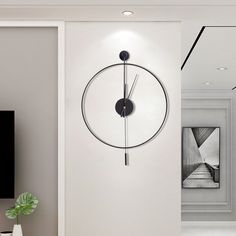 a modern clock mounted to the side of a wall in a living room next to a tv