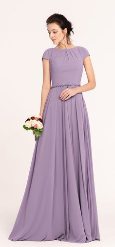 a woman in a long purple dress is holding a bouquet and posing for the camera