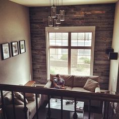 a man sitting on top of a couch in a living room next to a window