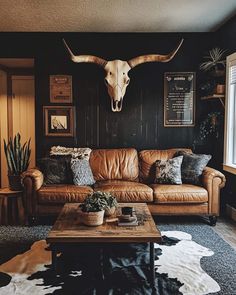 a living room filled with furniture and a cow skull mounted on the wall above it