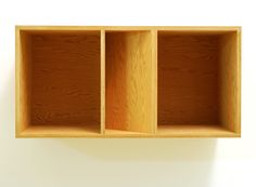 an empty wooden shelf with three compartments on each side and one section missing from the wall