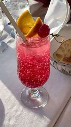 a glass filled with liquid and fruit on top of a table