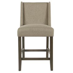 a beige upholstered bar stool with an armrest and foot rest in front of a white background