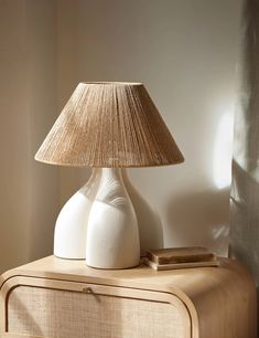 a white lamp sitting on top of a wooden table