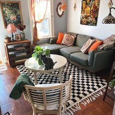 a living room filled with lots of furniture and decor on top of a hard wood floor