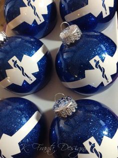 six blue and white christmas ornaments with arrows painted on the top one has a diamond ring