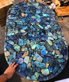 a table that has been made out of rocks and is being held up by someone's hand