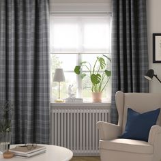 a living room filled with furniture and a window covered in curtained windowsills