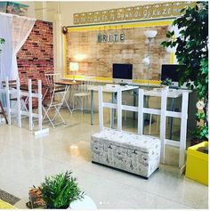 a living room filled with furniture next to a brick wall and floor covered in plants