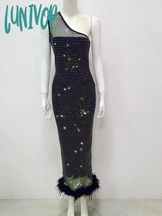 a mannequin wearing a black dress with sequins and feathers on it