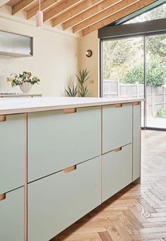 a kitchen with wooden floors and white counter tops