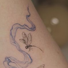 a woman's leg with a dragon tattoo on it