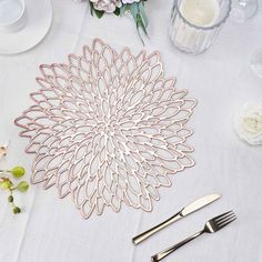 a white table topped with silverware and flowers