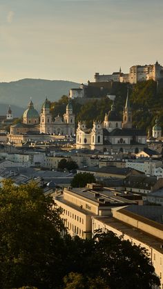 the city is surrounded by hills and trees, with many buildings on top of them