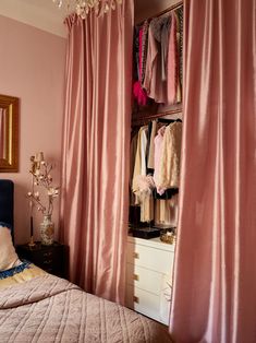 a bedroom with pink walls and curtains