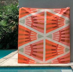 an orange and white quilt sitting on top of a swimming pool