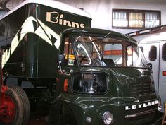 an old green truck parked in a garage