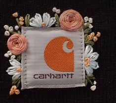 an embroidered patch with flowers and the word carnart on it's side