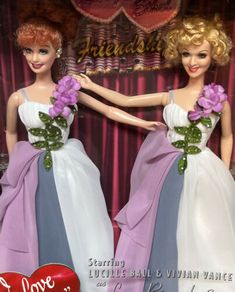 two barbie dolls dressed in evening gowns and holding hands