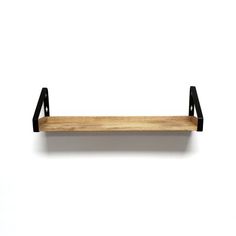 a wooden shelf sitting on top of a white wall next to a black metal frame