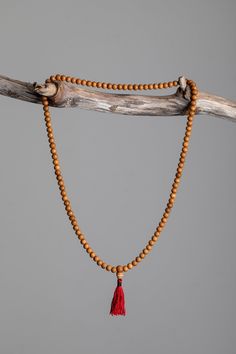 Each of these mala necklaces is made of 108 handcrafted Mala beads strung together with a red tassel. Traditionally used in Buddhist meditation, mala beads are used for counting all types of mantras, prayer, and meditations. When not in use, these beads are traditionally worn around the left wrist as a reminder to enrich the mind. The tassel marks the middle of the beads for counting. As a sign of respect, please do not let your mala beads touch the ground. Rosewood – a beautiful ebony wood asso Spiritual Wooden Beads Mala For Meditation, Spiritual Necklace With 108 Natural Beads, Holistic Wooden Beads Mala For Rituals, Traditional Natural Necklace For Meditation, Holistic Wooden Mala For Rituals, Natural Wooden Beads Necklace For Meditation, Paper Star Lanterns, Sandalwood Mala, Mala Beads Bracelet