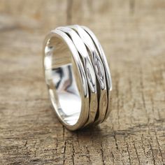 a silver ring sitting on top of a piece of wood with two lines in the middle