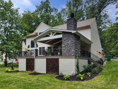 a large house with a stone chimney in the front yard