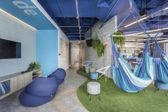 an office with hammock chairs and green carpeted flooring on the walls