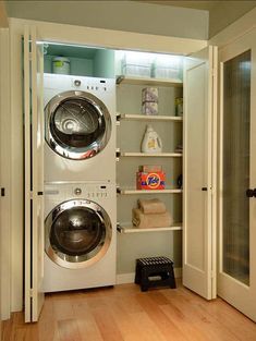 a washer and dryer in a room with wood flooring next to an open door