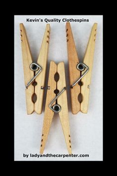 three wooden clothes pegs with metal clips attached to each other on a white background