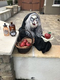 a creepy doll sitting on a ledge with apples