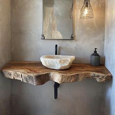 a bathroom sink sitting on top of a wooden counter next to a wall mounted mirror