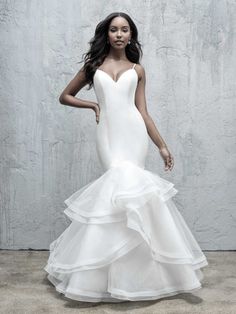 a woman in a white wedding dress posing for the camera with her hands on her hips