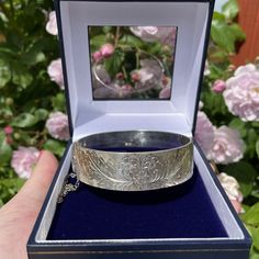 1960's Sterling silver heavy vintage bangle. This pretty sterling silver bangle has a flower and leaves engraving to the front, the reverse is plain.  A nice hinged bangle which could be stacked together with others or worn alone. The bangle has full clear and crisp sterling silver hallmarks dating it to Birmingham 1965-6. The fastener closes firmly and also has a safety chain.  The bangle has some small signs of wear such as surface scratches relative to its age.  Hallmarks  Assay Office-Anchor Engraved Bangle, Eco Wedding, Vintage Hair Accessories, Sustainable Wedding, Sterling Silver Bangle Bracelets, Vintage Bangles, Floral Bracelet, Sterling Silver Bangle, Silver Engraving